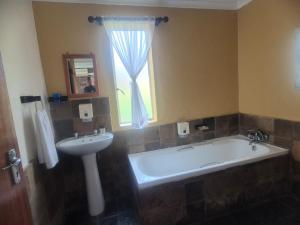 a bathroom with a tub and a sink and a window at Chargo River Lodge in Colesberg +21 photos