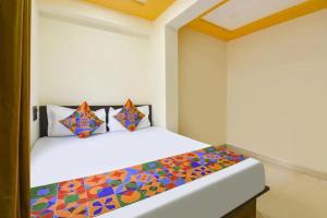 a bedroom with a bed with a colorful comforter at FabHotel Silver Star in Pune