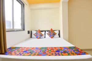 a bedroom with a large bed with a colorful comforter at FabHotel Silver Star in Pune