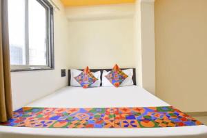 a bedroom with a bed with a colorful comforter at FabHotel Silver Star in Pune