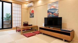 a living room with a television and a table at 楓 和室の一棟貸切 最大10名宿泊可能 駅徒歩2分 関西空港直通 in Osaka