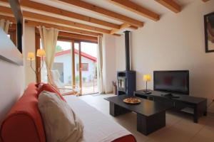 ein Wohnzimmer mit einem roten Sofa und einem Fernseher in der Unterkunft Burkia in Sare