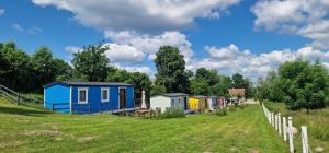 a row of tiny houses in a field at Niezła Szopka domki nad jeziorem in Nowe Guty