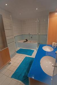 a bathroom with two sinks and a tub and two mirrors at Ferienwohnung Marienhof in Bad Aussee +35 photos