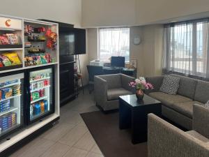 a living room with two couches and a refrigerator at Comfort Inn Saskatoon Centre in Saskatoon