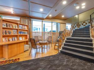 a library with stairs and a table and chairs at Subaruyado Yoshino in Tokushima