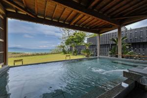 a swimming pool in a backyard with a wooden roof at Yuhigaura Onsen Ryotei KAI in Kyotango