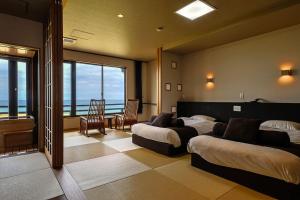 a hotel room with two beds and a view of the ocean at Yuhigaura Onsen Ryotei KAI in Kyotango