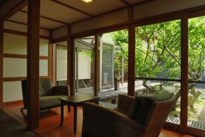 a screened in porch with chairs and a table at Yuhigaura Onsen Ryotei KAI in Kyotango