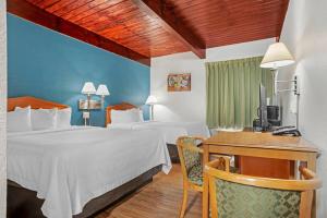 a hotel room with two beds and a desk at Econo Lodge Tallahassee Downtown - University in Tallahassee