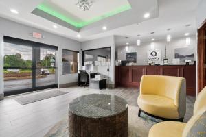 a living room with a table and a yellow chair at Quality Inn Adairsville-Calhoun South in Adairsville