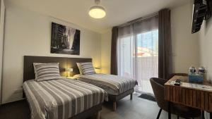 a hotel room with two beds and a window at Villa Lagune in Les Sables-d'Olonne +36 photos