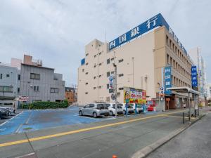 a parking lot with cars parked in front of a building at Subaruyado Yoshino in Tokushima