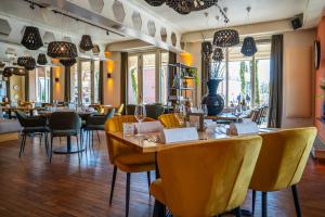 a restaurant with a table and chairs and tables and chairsearcher at Kruller - Hotel B&B in Otterlo