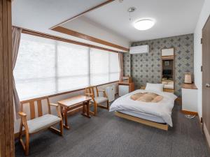 a bedroom with a bed and chairs and a window at Subaruyado Yoshino in Tokushima +85 photos