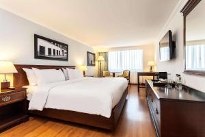 a hotel room with a large bed and a desk at Radisson Bogota Metrotel in Bogotá