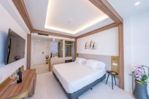 a bedroom with a bed and a desk in a room at Hotel Faranda Rias Altas, Ascend Hotel Collection in Oleiros