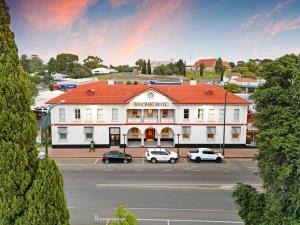 a large white building with cars parked in a parking lot at Kincraig Hotel in Naracoorte