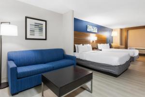 a hotel room with a bed and a blue couch at Comfort Inn & Suites Tyler North in Tyler +35 photos