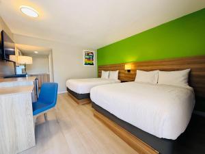 a hotel room with two beds and a green wall at Park Inn by Radisson, Quesnel in Quesnel