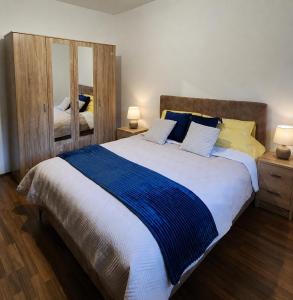 a bedroom with a large bed with blue and yellow pillows at Odmaralište BP in Bijelo Polje