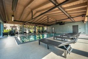 a swimming pool with benches and tables in a building at Penzion Panorama - Celoročný krytý bazén v cene in Liptovský Mikuláš