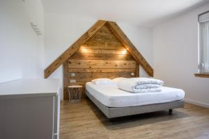 a bedroom with a bed with a wooden roof at Gîte Perce Neige, Spa, Sauna in Gerbépal