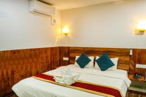 a bedroom with a bed with blue and white pillows at Bardibas Resort in Tulsi +38 photos
