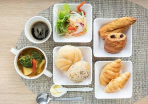a table with plates of food and a cup of coffee at Super Hotel Kushiro-Ekimae in Kushiro