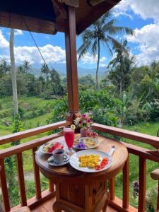 a table with plates of food on a balcony at Pandawa Villa Sidemen in Karangasem