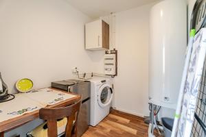 a small kitchen with a washing machine and a table at La Grange in Reichstett