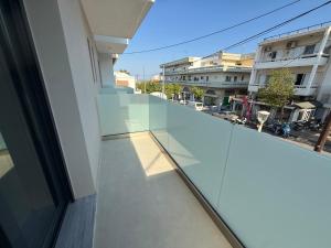 a glass balcony with a view of a street at Olympus Hospitality Rhodes in Rhodes Town