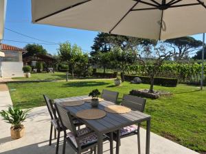 a wooden table with chairs and an umbrella at Mareya Premium Stay in Poreč