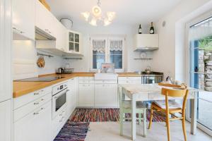 a kitchen with white cabinets and a wooden table at Anika’s Home in Valfloriana
