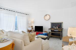 a living room with a white couch and a tv at Anika’s Home in Valfloriana