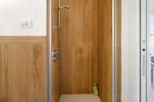 a shower with a wooden door in a bathroom at Anika’s Home in Valfloriana +30 photos