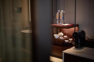 a bathroom with bottles and cups on a shelf at HUALUXE Beijing Xinan in Beijing