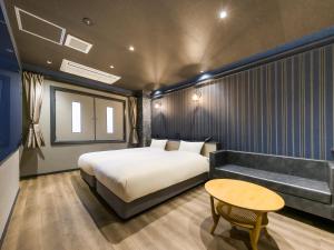a bedroom with a bed and a table at Hotel Noir Blanc in Shizuoka