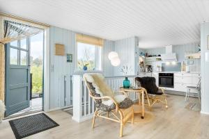 a kitchen with blue walls and a table and chairs at 8528-Grenaa-Klitten-28 in Grenå