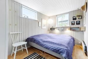 a bedroom with a bed and a chair in it at 8528-Grenaa-Klitten-28 in Grenå