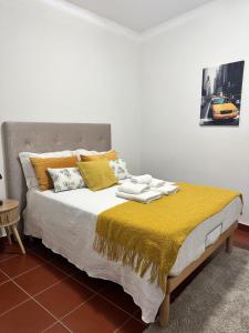 a bedroom with a bed with a yellow blanket at Casa da Avó Ilda in Miranda do Douro