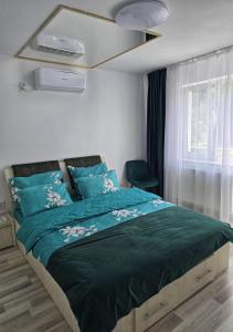 a bedroom with a bed with a green comforter at Ram house1 in Piteşti