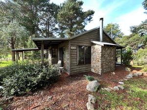 a small cabin in a field with a chair at Turicum AT Monkey Rock Winery & Cider in Parryville
