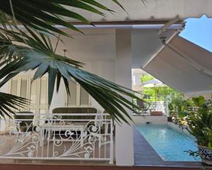 a balcony with a pool and a table and chairs at Villa Dyrrahu with Pool & Sea Access in Golem