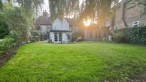 a yard with a house with a green lawn at Garden View Homestay in Historic Patcham, Brighton in Brighton & Hove