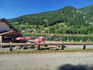 a lake with tables and umbrellas and people in the water at Studio Appartement Grand Serre in La Morte