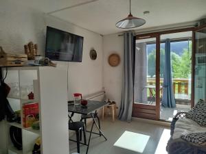 a living room with a table and a sliding glass door at Studio Appartement Grand Serre in La Morte