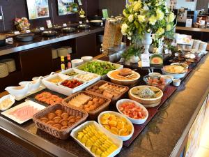 a buffet with many different types of food on a counter at Odysis Suites Osaka Airport Hotel in Izumi-Sano