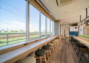 a row of stools in a room with large windows at Super Hotel Kushiro-Ekimae in Kushiro