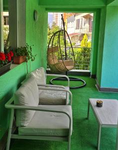 a green room with a bed and a table and a window at Ram in Piteşti +8 photos